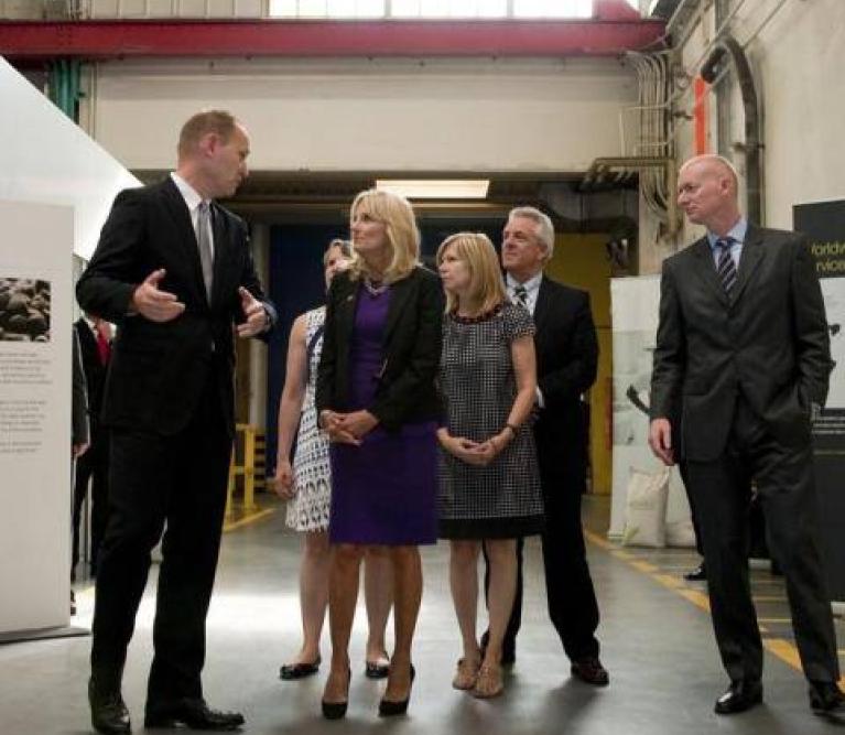 Jill Biden mit weiteren Personen in einer Fabrikhalle